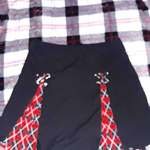 Small black and red plaid skirt with metal crossed clips.